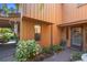 Inviting front entrance with a decorative door, complemented by verdant landscaping and exterior lighting at 115 Oaks Ct # 115, Sanford, FL 32771