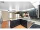 Kitchen view showcasing granite counters, dark cabinets, breakfast bar, stainless steel appliances, and light filled dining space at 115 Oaks Ct # 115, Sanford, FL 32771