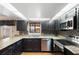 Well-lit kitchen boasts granite counters, stainless steel appliances, and dark cabinets with mosaic tile backsplash at 115 Oaks Ct # 115, Sanford, FL 32771