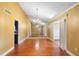 Spacious living room with hardwood floors, chandelier, and mirrored wall creating an open and airy atmosphere at 115 Oaks Ct # 115, Sanford, FL 32771