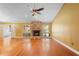 Bright living room with hardwood floors, a stone fireplace, large windows, and a ceiling fan at 115 Oaks Ct # 115, Sanford, FL 32771