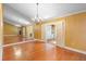 Spacious living room enhanced by hardwood flooring, a striking fireplace, and mirrored accent walls under a stylish chandelier at 115 Oaks Ct # 115, Sanford, FL 32771