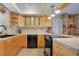 Compact kitchen featuring wood cabinetry and black appliances at 1155 E Fowler Dr, Deltona, FL 32725