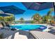 Sparkling pool with lounge chairs and umbrellas, perfect for relaxation and outdoor enjoyment at 1155 E Fowler Dr, Deltona, FL 32725