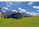 Expansive backyard featuring lush green grass and a screened lanai for outdoor enjoyment at 1183 Cabot Cliffs Dr, Daytona Beach, FL 32124