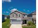 Charming two-story home with gray siding, a well-manicured lawn and inviting front entrance at 1183 Cabot Cliffs Dr, Daytona Beach, FL 32124