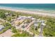 Aerial view of a home with ample parking, beach access and lush landscaping at 1209 N Atlantic Ave, New Smyrna Beach, FL 32169