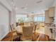 Open dining and kitchen area with a round table, granite countertops, and views of the ocean from the windows at 1209 N Atlantic Ave, New Smyrna Beach, FL 32169