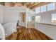Hallway with hardwood floors, wooden ceiling beams, and access to a bathroom at 1209 N Atlantic Ave, New Smyrna Beach, FL 32169