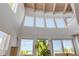 Bright living room with high ceilings, wood beams, and ocean view windows offering ample natural light and coastal scenery at 1209 N Atlantic Ave, New Smyrna Beach, FL 32169