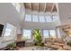 Spacious living room features large windows with ocean views, vaulted ceilings, and a cozy fireplace at 1209 N Atlantic Ave, New Smyrna Beach, FL 32169