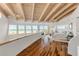 Bright main bedroom with hardwood floors, wood-beamed ceilings, beach views, and access to a balcony at 1209 N Atlantic Ave, New Smyrna Beach, FL 32169