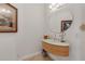 Modern powder room with a unique floating sink, round mirror, and stylish decor offering a sleek, contemporary design at 1209 N Atlantic Ave, New Smyrna Beach, FL 32169