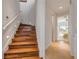 Staircase featuring hardwood steps, white risers, and ambient lighting, leading to a bedroom at 1209 N Atlantic Ave, New Smyrna Beach, FL 32169