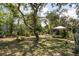 Backyard featuring a leafy tree, lush grass, and a white tent at 1284 Vanderbilt Dr, Ormond Beach, FL 32174