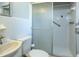 Well-lit bathroom featuring a classic vanity, toilet, and enclosed shower with safety bar at 1284 Vanderbilt Dr, Ormond Beach, FL 32174