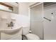 Well-lit bathroom featuring a classic vanity, toilet, and enclosed shower with safety bar at 1284 Vanderbilt Dr, Ormond Beach, FL 32174