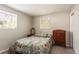 Sunny bedroom showcasing a floral-patterned bedspread, and a wooden dresser at 1284 Vanderbilt Dr, Ormond Beach, FL 32174