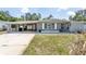 Charming single-story home with a gray exterior, carport, and well-maintained front yard at 1284 Vanderbilt Dr, Ormond Beach, FL 32174