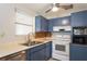 Kitchen featuring blue cabinets, stainless steel dishwasher, and tiled backsplash at 1284 Vanderbilt Dr, Ormond Beach, FL 32174