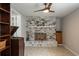 Spacious living room featuring a striking brick fireplace, ceiling fan and vintage record player at 1284 Vanderbilt Dr, Ormond Beach, FL 32174