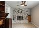 Spacious living room featuring a striking brick fireplace, ceiling fan and vintage record player at 1284 Vanderbilt Dr, Ormond Beach, FL 32174