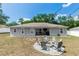 Backyard featuring a firepit with chairs, patio area, and a well-maintained lawn at 1326 13Th St, Orange City, FL 32763