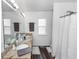 Bright bathroom with double vanity, large mirror, and a shower behind a curtain at 1326 13Th St, Orange City, FL 32763
