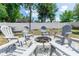 Firepit in backyard with six Adirondack chairs over a bed of decorative gravel at 1326 13Th St, Orange City, FL 32763