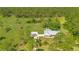 Aerial view of home with a metal roof surrounded by lush green trees and expansive lawns at 140 Rodeo Rd, Ormond Beach, FL 32174