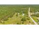 Picturesque aerial view featuring a home with a barn, situated on a large lot surrounded by verdant landscape and mature trees at 140 Rodeo Rd, Ormond Beach, FL 32174