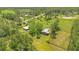 Sprawling property featuring a farmhouse, additional barn, and lush green pastures surrounded by beautiful wooded areas at 140 Rodeo Rd, Ormond Beach, FL 32174