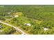 Scenic aerial view of a property featuring a home, lush pastures, mature trees, and a well-maintained road at 140 Rodeo Rd, Ormond Beach, FL 32174