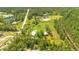 Expansive aerial view showcases a charming property with a home, barn, and well-maintained pastures with lush greenery at 140 Rodeo Rd, Ormond Beach, FL 32174