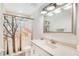 Bright bathroom featuring a sink, toilet, mirror, and a shower with a nature-themed curtain at 140 Rodeo Rd, Ormond Beach, FL 32174