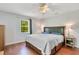Well lit bedroom with hardwood floors, a ceiling fan and large bed under a window bringing in natural light at 140 Rodeo Rd, Ormond Beach, FL 32174