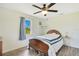 Bedroom with wood floors, a ceiling fan, and a large window overlooking nature at 140 Rodeo Rd, Ormond Beach, FL 32174