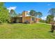 Single-story home with a screened porch, two-car garage, and a well-maintained lawn on a sunny day at 140 Rodeo Rd, Ormond Beach, FL 32174