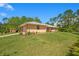 A single-story home featuring a two-car garage, concrete driveway and a well-maintained lawn and tropical landscaping at 140 Rodeo Rd, Ormond Beach, FL 32174
