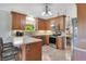 Traditional kitchen with tiled floors, stainless appliances, and wooden cabinets, plus eat-in bar at 140 Rodeo Rd, Ormond Beach, FL 32174