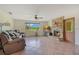 Comfortable living room featuring a stone fireplace, tiled floors, and large windows providing natural light and green views at 140 Rodeo Rd, Ormond Beach, FL 32174