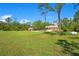Sprawling property featuring a well-maintained lawn, mature trees, and additional outbuildings, offering ample space at 140 Rodeo Rd, Ormond Beach, FL 32174