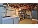 Basement laundry area includes washer, dryer, shelving for storage, and stairs to the main level at 145 S Peninsula Dr, Daytona Beach, FL 32118