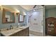 Updated bathroom featuring double vanity, stylish mirrors, and a bathtub with a shower at 145 S Peninsula Dr, Daytona Beach, FL 32118