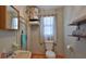 Functional bathroom with terracotta tile, exposed pipes and a window with natural light at 145 S Peninsula Dr, Daytona Beach, FL 32118