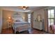 Bright bedroom features wood floors, large windows, and an antique dresser with accent lighting at 145 S Peninsula Dr, Daytona Beach, FL 32118