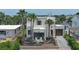 Charming home featuring tropical landscaping, a dark-framed entrance, and an attached garage, all adding to its curb appeal at 145 S Peninsula Dr, Daytona Beach, FL 32118