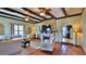Warm living room with beamed ceiling, fireplace, and access to kitchen at 145 S Peninsula Dr, Daytona Beach, FL 32118