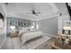 Stylized bedroom with a modern farmhouse design, including wood-look accent wall, tray ceiling, and neutral color palette at 1491 Nappa Dr, Port Orange, FL 32128