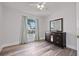Bedroom showcasing wood-look floors, window with views, and dark wood dresser with mirror at 1491 Nappa Dr, Port Orange, FL 32128